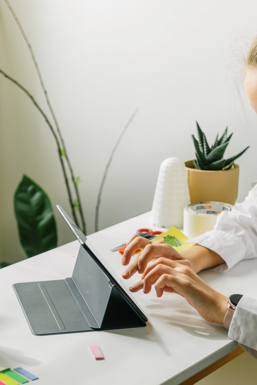 person in white long sleeve shirt using digital tablet