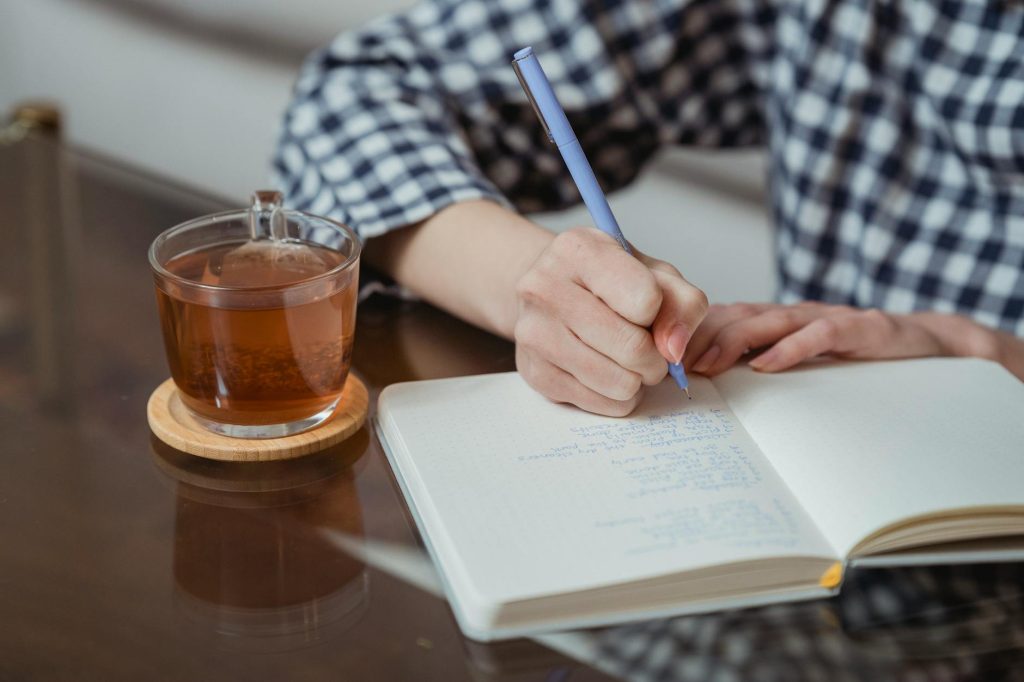 Current image: woman writing notes in a notebook