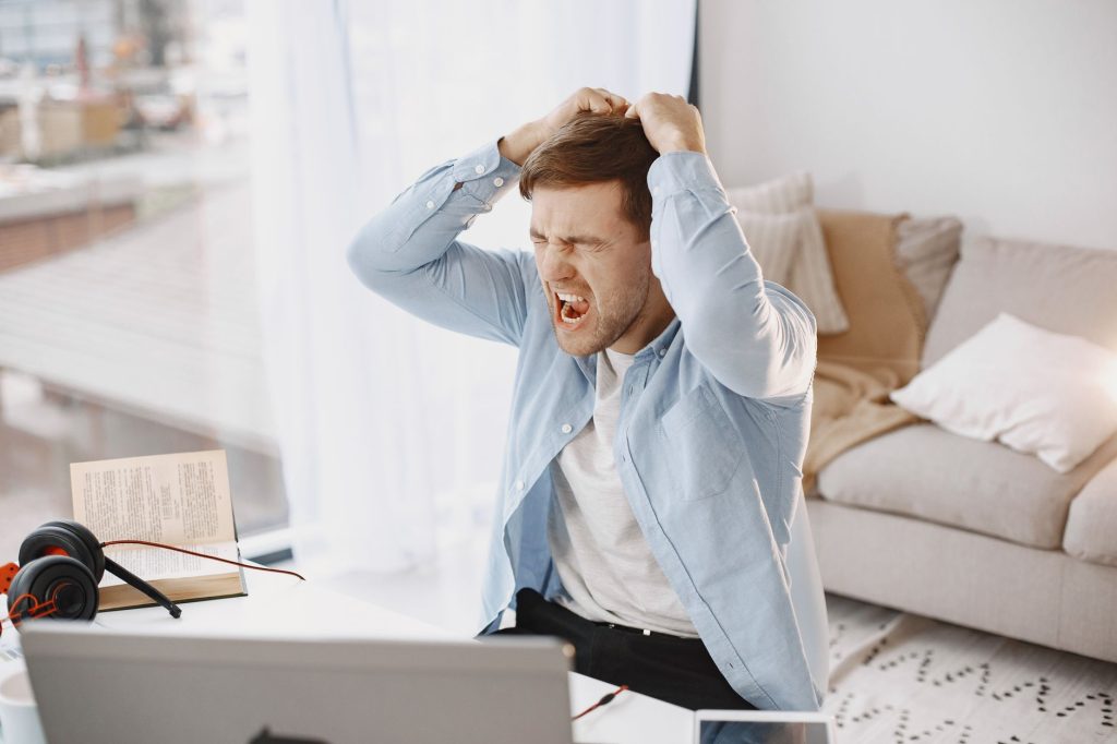 Current image: upset man shouting at desk